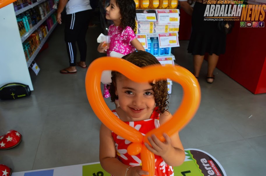 Criança sorrindo com balão em formato de coração